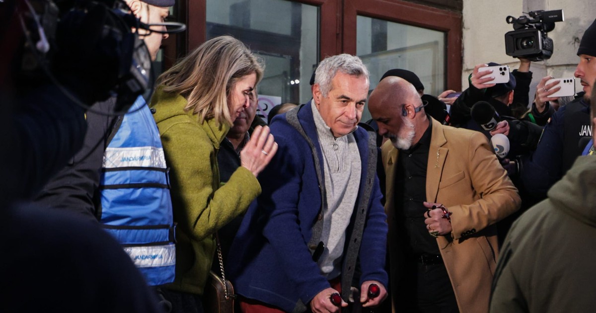 Călin Georgescu în cârje pe treptele de la Parchetul General, cu Cristela Georgescu lângă el.