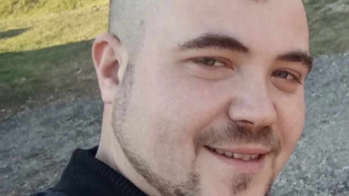 Tânărul mort în accident, în prim plan, îmbrăcat cu o geacă neagră, iar pe fundal o stradă neasfaltată