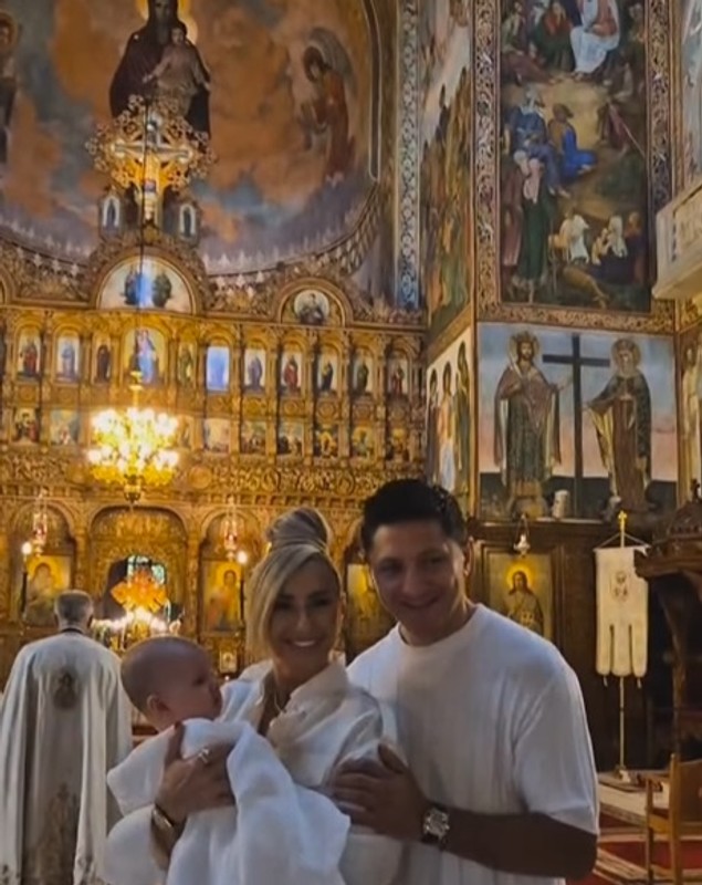 Anamaria Prodan și Ronald Gavril, în postura de nași de botez. Îmbrăcați în alb, au devenit părinții spirituali ai unui băiețel