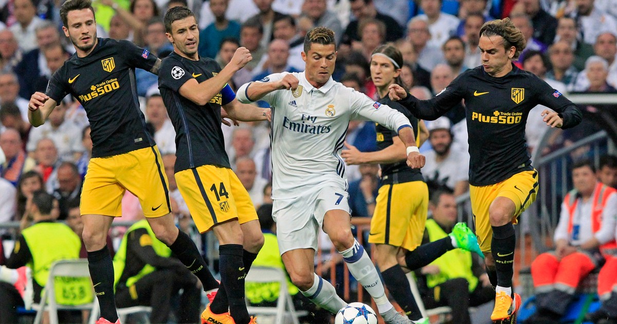 Cristiano Ronaldo (în alb), înconjurat de patru fotbaliști ai lui Atletico Madrid, a făcut prăpăd în careul rivalei lui Real Madrid. (FOTO: EPA)