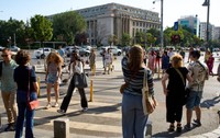 București, România – 25 iunie 2024: Oamenii traversează strada în apropierea Palatului Victoria, care găzduiește sediul Guvernului României, în București.