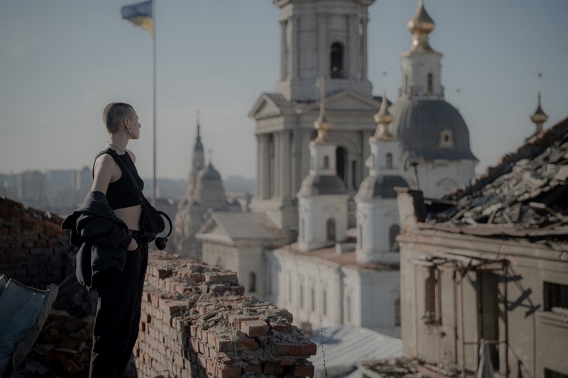 Valentyna Guk stă pe acoperișul unei clădiri grav avariate din centrul orașului Harkov, pe 7 martie 2025, în timpul invaziei rusești în Ucraina. Foto. AFP