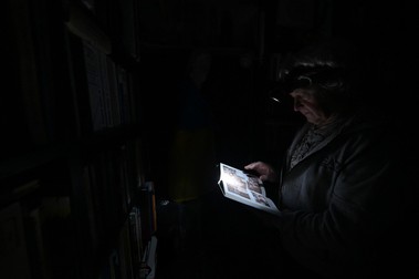 Fizicianul Igor Zhuk, în vârstă de 70 de ani, citește o carte cu ajutorul unei lanterne purtate pe cap, în timpul unei întreruperi de curent într-o clădire din nordul Kievului, pe 5 noiembrie. | Foto: Profimedia