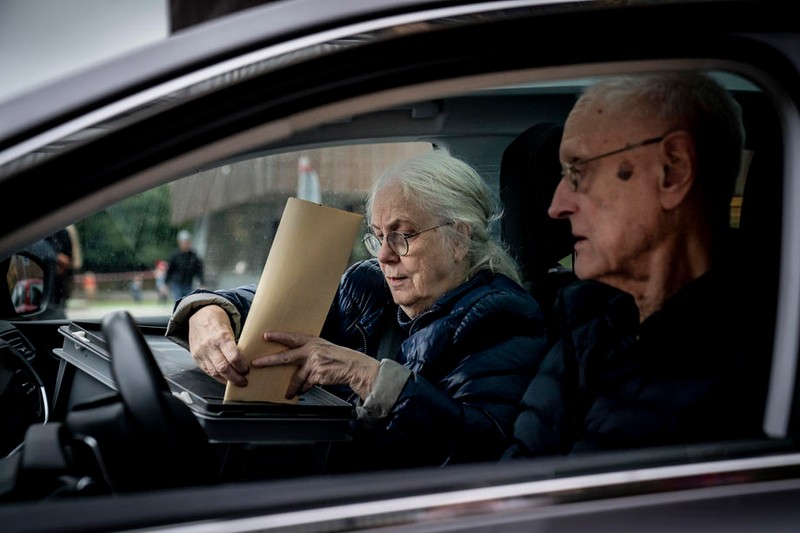 O femeie introduce buletinul de vot în urnă, după ce a votat din mașină, din cauza regulilor speciale. Foto: Epa