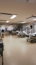 Fotografie făcută luni, 18 octombrie, la spitalul modular de la Piatra Neamț. Pe fundal, doi dintre angajații spitalului care au în grijă pacienții internați aici cu COVID