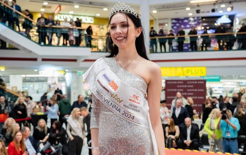 Miss Vienna 2024, Lucia Sisic, la evenimentul Miss și Mister Vienna, în rochie strălucitoare argintie, cu coroană pe cap, multă lume se vede în spate