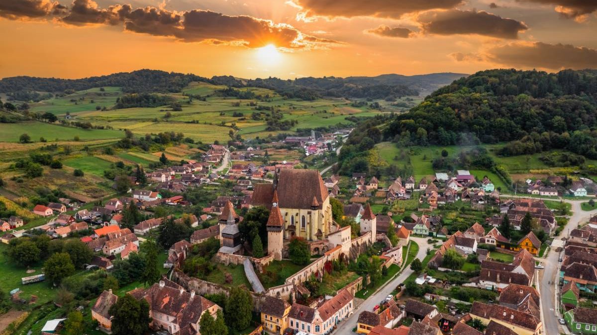 Vedere aeriană a satului Biertan cu biserica fortificată la apus. Transilvania, România