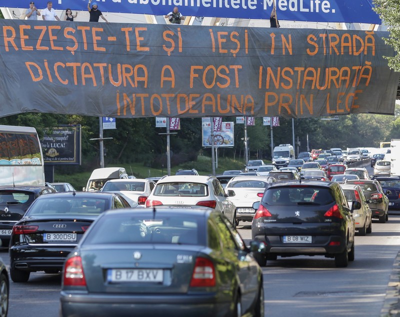 FOTO / Acţiuni împotriva OUG privind amnistia şi graţierea, în Capitală. Banner pe podul de la Fântâna Morița și incidente în Piața Victoriei