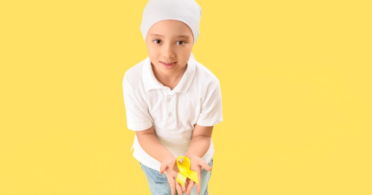 Fetiță după chimioterapie cu panglică galbenă pe fundal colorat. Conceptul de conștientizare a cancerului în copilărie, Sursă foto: Profimedia