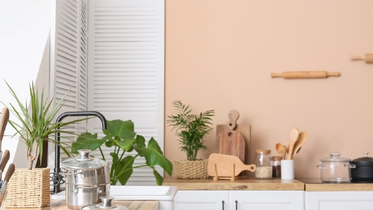Interior modern de bucătărie cu blat din lemn și ustensile de bucătărie pentru prepararea mâncărurilor, într-un apartament confortabil