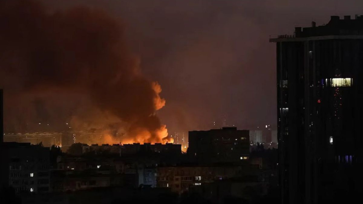 Un incendiu se vede în depărtare, în timpul nopții, la Kiev, după ce rușii au bombardat cu drone Shahed, 21-22 octombrie 2025