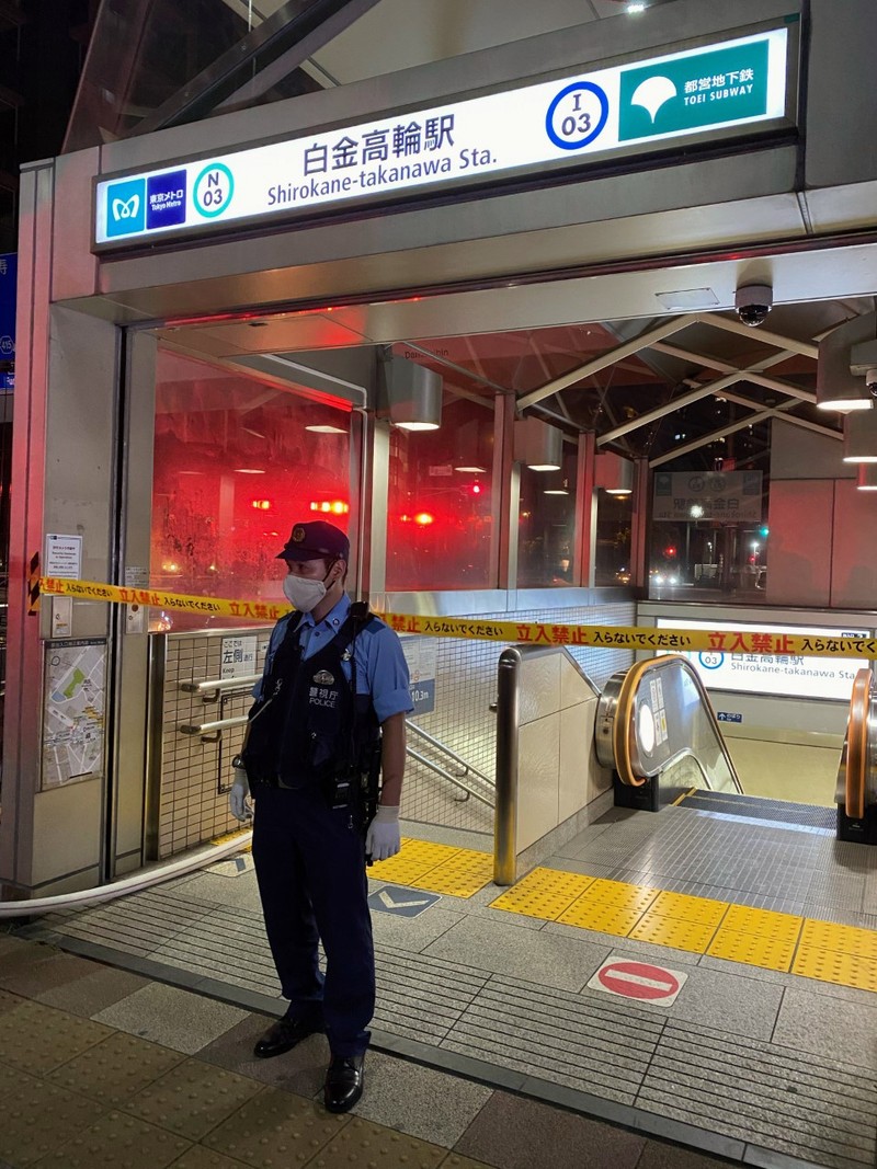 Un polițist păzește intrarea în stația de metrou Shirokane Takanawa din Tokyo, unde două persoane au suferit răni în urma unui atac acid | Foto: EPA