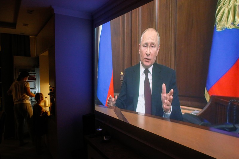 O familie rusească ascultă discursul în care Vladimir Putin anunță că Rusia va recunoaște independența regiunilor separatiste din estul Ucrainei, 21 februarie 2022 | Foto: Profimedia