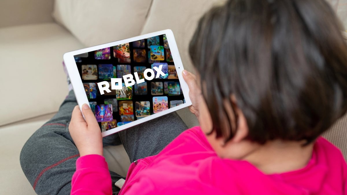 Un copil stă pe canapea și se joacă roblox