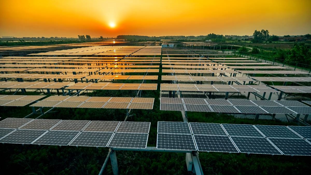 Fotografie aeriană a panourilor solare fotovoltaice de pe suprafața lacului sub apusul soarelui