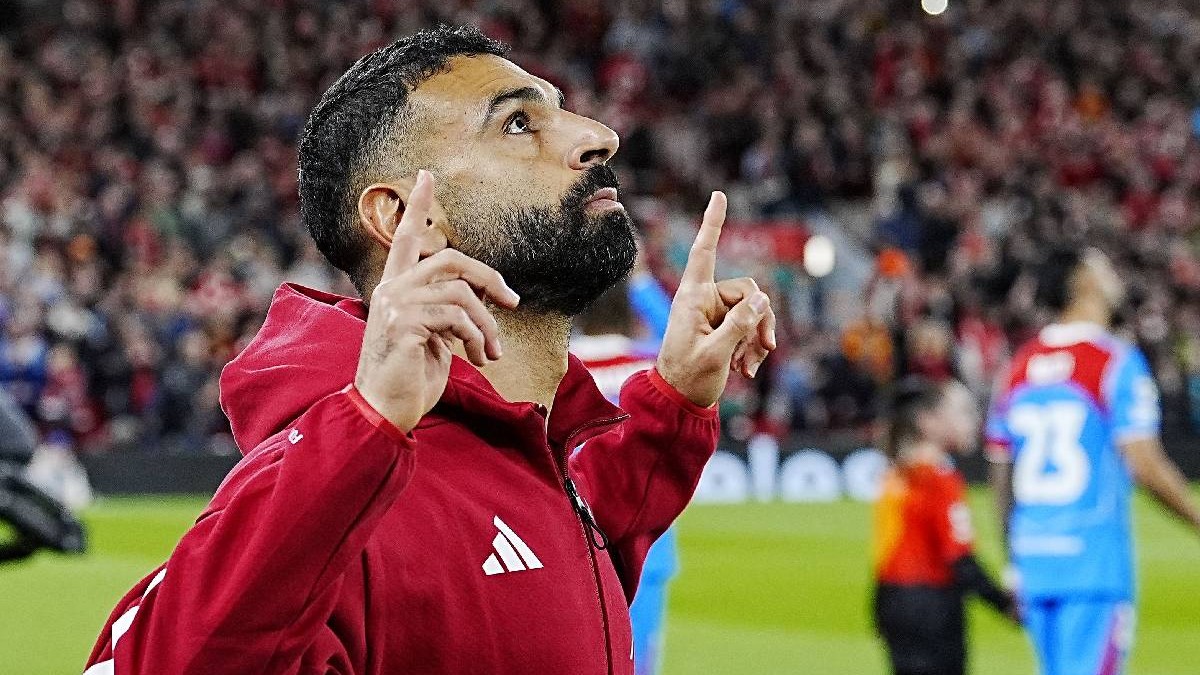 Starul Liverpool-ului, Mohamed Salah, pe terenul de fotbal, privește în sus parcă mulțumind