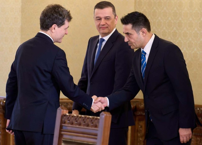 Secretarul general al PSD, Claudiu Manda, dă mâna cu președintele Nicușor Dan pe 18 mai 2026, la Cotroceni, înaintea consultărilor pentru noul premier. Președintele PSD, Sorin Grindeanu, privește. Foto: Profimedia