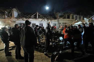 Voluntarii și fanii clubului de fotbal Dinamo Zagreb îndepărtează molozul din clădirile avariate din Petrinja. Foto: Profimedia
