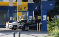 Mai multe autoturisme sunt staționate la pompele de alimentare ale unei stații de carburant.