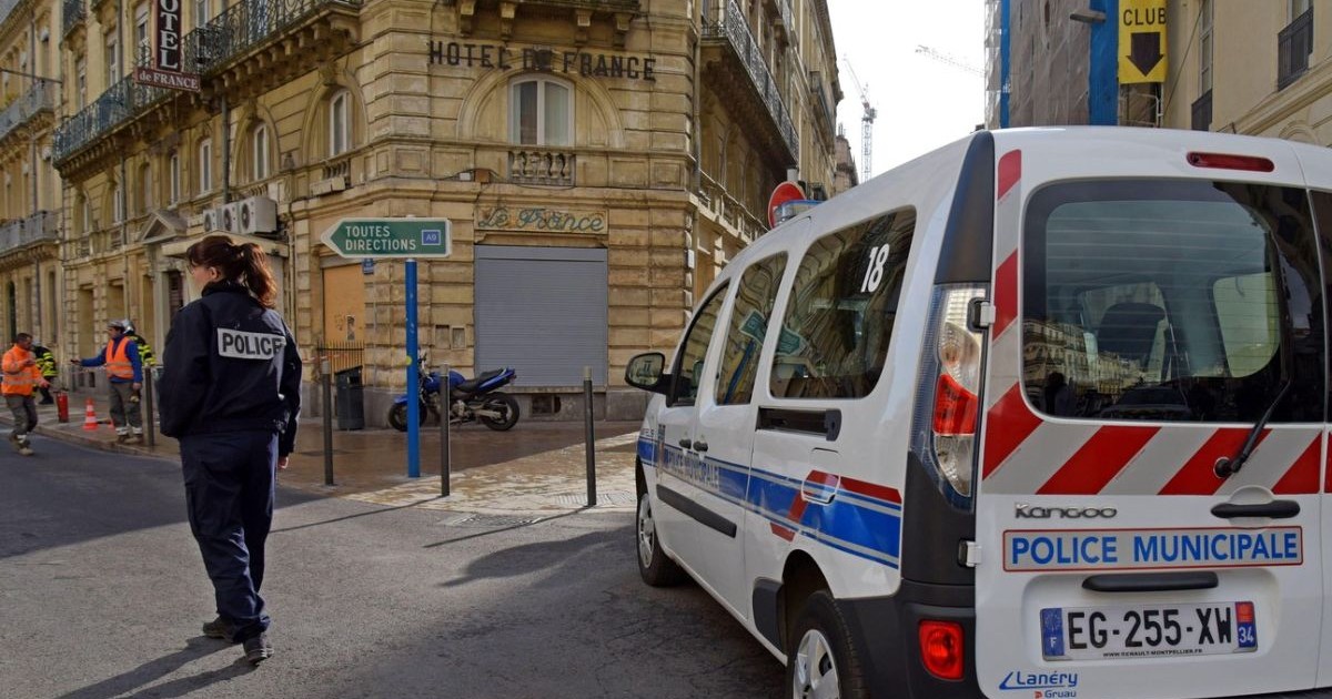 Prim plan mașină de poliție din Franța în plină stradă, alaturi o femeie polițist care a închis o stradă pentru un incident în Montpellier, Franța
