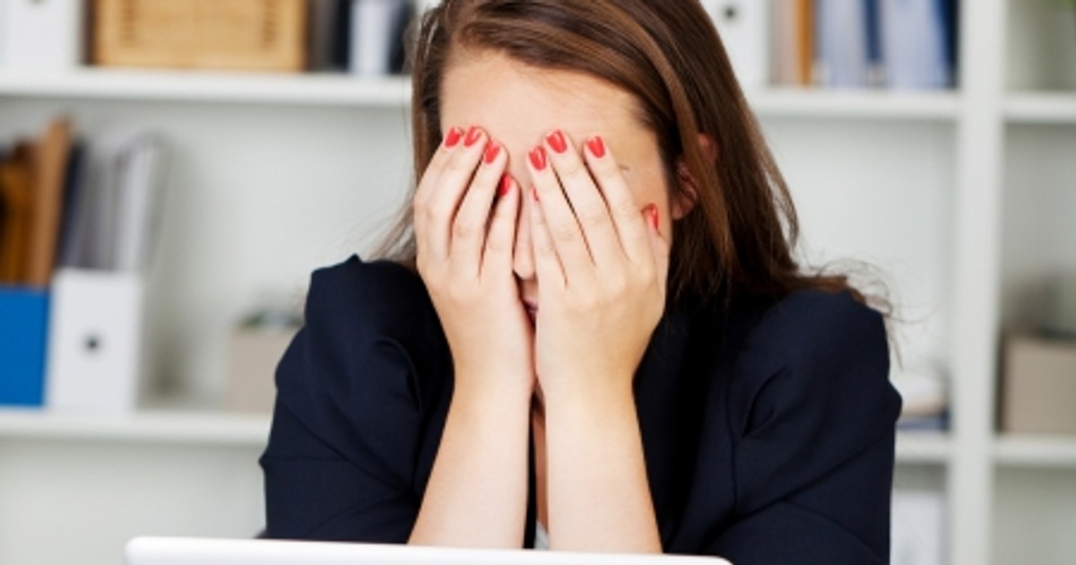 Sindromul burnout, asasinul tăcut de la muncă. Angajată în fața unui calculator cu mâinile la ochi
