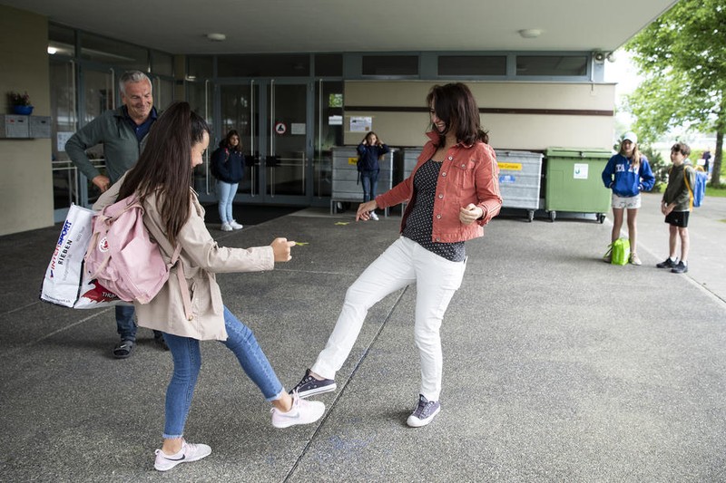 Profesoara Bianca Betschen (dreapta) se salută cu Yanira Ribeiro Perez, la școala primară Neufeld, Thun, respectând regulile de distanțare socială. Foto: EPA