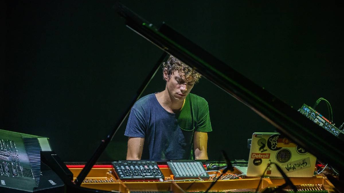 Francesco Tristano, îmbrăcat într-un tricou albastru, mixează muzică într-un studio