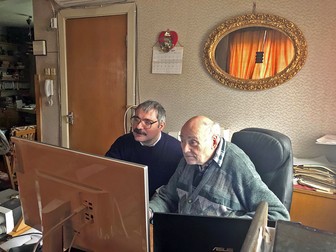Mircea Pauca, stânga, se uită împreună cu tatăl sau la fotografii din arhiva familiei
