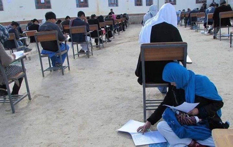 FOTO | Ipostaza care face înconjurul lumii: O tânără afgană are grijă de bebelușul ei în timp ce dă examenul pentru admitere la universitate