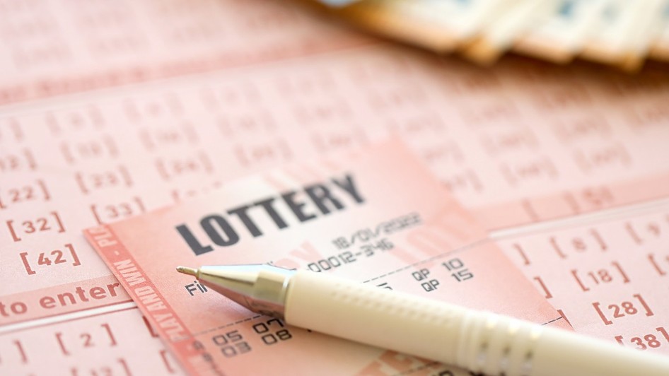 Un pix pe un bilet la loto. În fundal se văd mai multe bancnote 