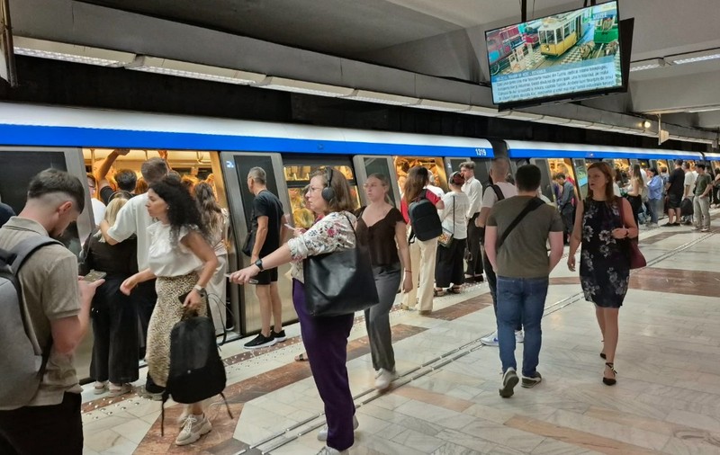 Zeci de oameni care stau pe peronul unei stații de metrou din București 