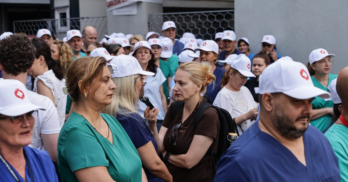O asistenta medicala cu sapca alba de protestatar povesteste reporterului Libertatea de ce face greva. Intr-o multime de protestatari la Spitalul Floreasca
