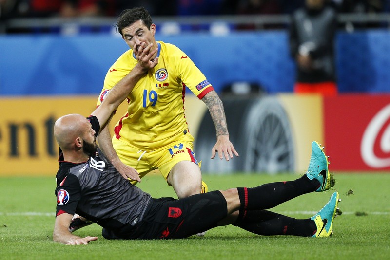 epa05378217 Arlind Ajeti (bottom) of Albania in action against Bogdan Stancu of Romania during the UEFA EURO 2016 group A preliminary round match between Romania and Albania at Stade de Lyon in Lyon, France, 19 June 2016. (RESTRICTIONS APPLY: For editorial news reporting purposes only. Not used for commercial or marketing purposes without prior written approval of UEFA. Images must appear as still images and must not emulate match action video footage. Photographs published in online publications (whether via the Internet or otherwise) shall have an interval of at least 20 seconds between the posting.) EPA/SERGEY DOLZHENKO EDITORIAL USE ONLY