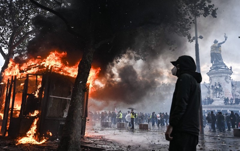 Protestatari în Franța au incendiat o stație de autobuz și vandalizează o statuie. Unul dintre protestatari este mascat