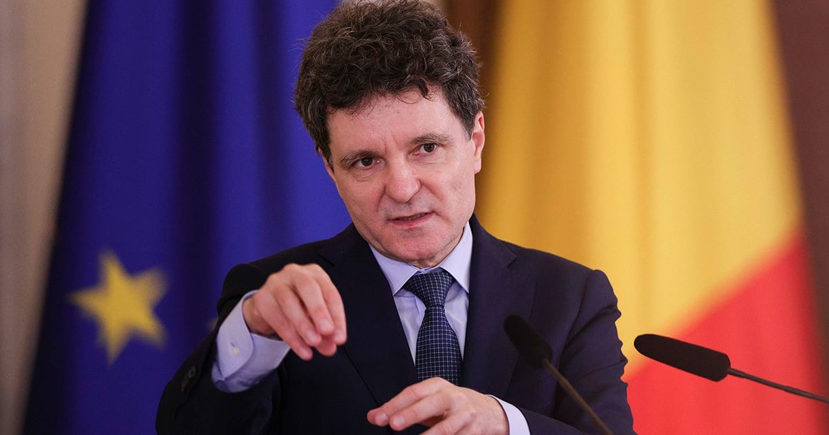 Nicușor Dan îmbrăcat într-un costum negru, cămașă bleu, cravată neagră cu mici puncte albe, explică ceva arătând cu mâinile.