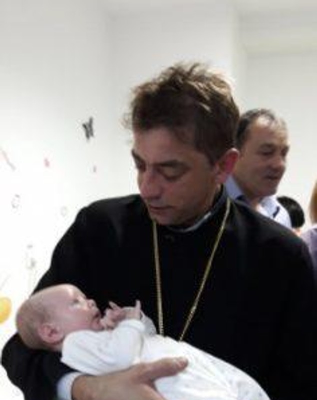 Un bebeluș aruncat de mama sa într-un pârâu a fost botezat. Nași i-au fost asistenta și polițistul care l-au salvat