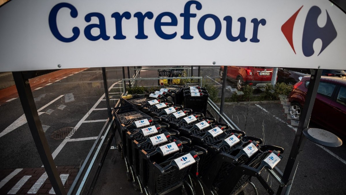 Sigla Carrefour într-un loc de depozitare a cărucioarelor dintr-o parcare