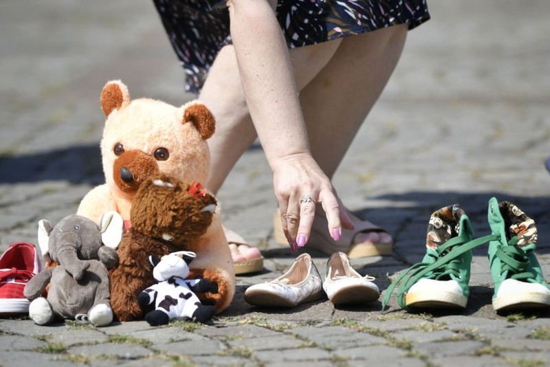O tânăra depune una din cele 400 de perechi de pantofi, pentru fiecare copil care dispare anual, în fața Ministerului Afacerilor Interne, sâmbătă, 3 august 2019 | FOTO: ANDREEA ALEXANDRU / MEDIAFAX FOTO