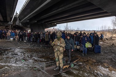 Oamenii din Irpin trec peste un pod distrus pentru a părăsi orașul | Foto: EPA