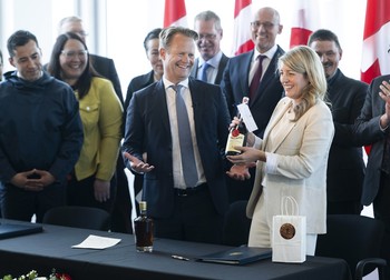 Ministrul danez de externe Jeppe Kofod și omologul său canadian Melanie Joly au făcut schimb de whiskey și rachiu după semnarea unui acord care va împărți insula Hans în două părți. Foto: Profimedia