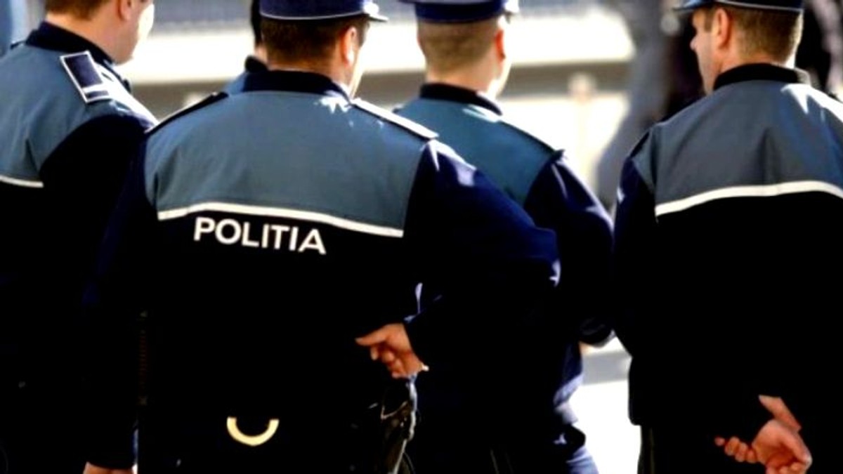 Polițiștii din Giurgiu învaţă tehnici de ju-jitsu. Polițiști care stau cu spatele. Unul dintre ei are cătușe la el și ține mâna dreaptă la spate. Altul ține ambele mâini la spate