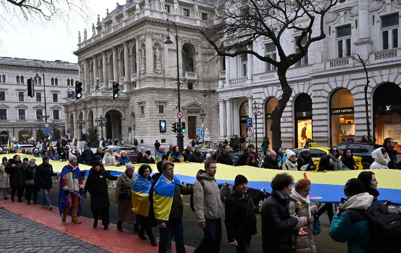 Oamenii poartă un steag ucrainean uriaș în fața Ambasadei Rusiei în cadrul unui marș de solidaritate în sprijinul Ucrainei, organizat la Budapesta, duminică, 22 februarie 2026