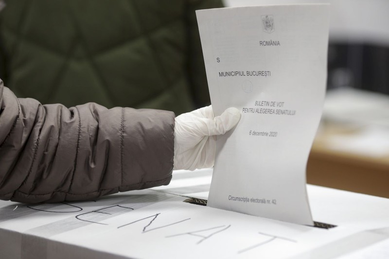Un alegător introduce un buletin de vot în urnă