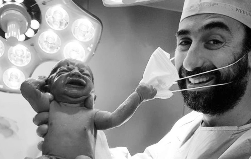 Imagine virală: Un nou-născut smulge masca medicului imediat după ce vine pe lume. „Cu toții vrem un semnal că ne vom da jos în curând măștile”