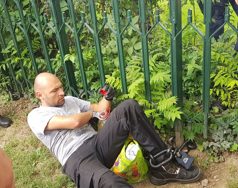UPDATE. Bărbatul care s-a legat cu lanțul de gardul Guvernului și avea asupra lui o sticlă de benzină a fost descarcerat si ridicat de Jandarmerie (FOTO / VIDEO)