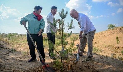 La 26 de ani de la prima întâlnire, un profesor american și familia pe care a ajutat-o plantează împreună un nou copac în deșertul Mu Us. Sursa foto: Profimedia Images
