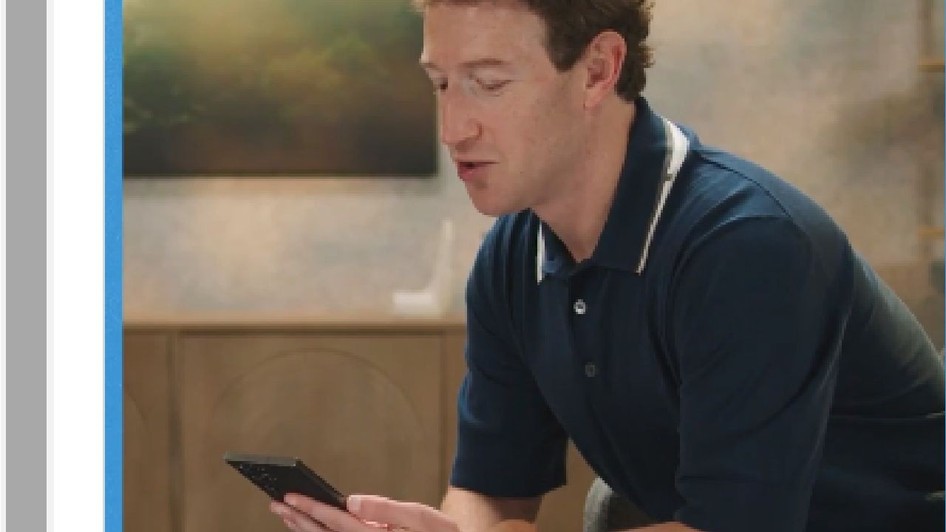 Mark Zuckerberg ține în mâini un smartphone negru