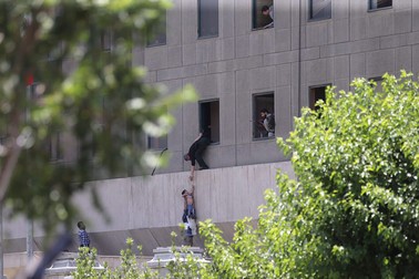 epa06014196 Iranian policemen try to help some civilians fleeing from the parliament building during an attack in Tehran, Iran, 07 June 2017. At least seven people were killed and several others were wounded following twin attacks on Iran's parliament building and the mausoleum of former supreme leader, Ayatollah Khomeini, in the Iranian capital Tehran on 07 June, according to official sources. EPA/OMID WAHABZADEH