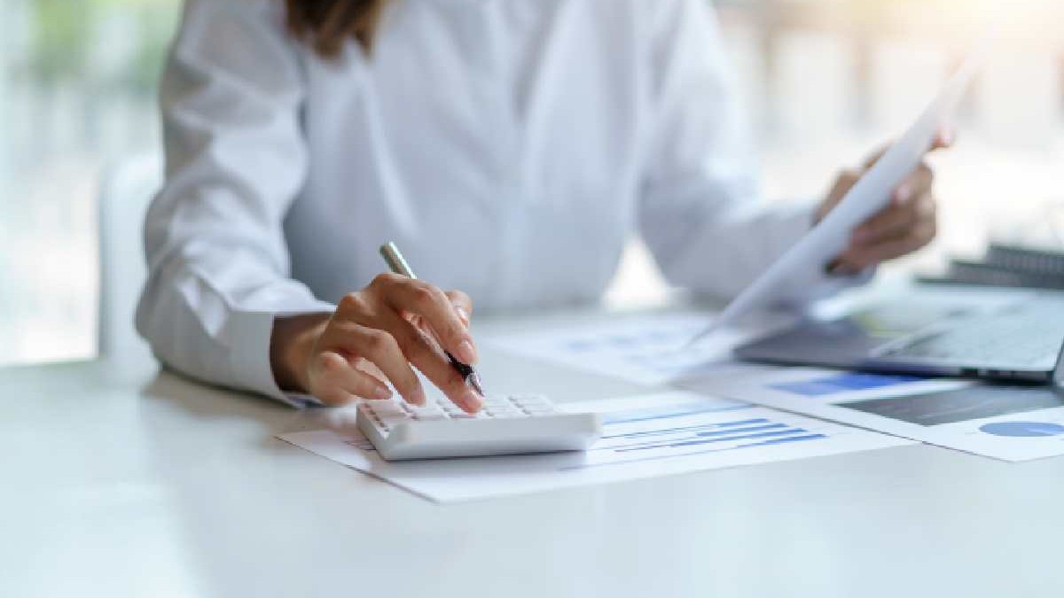 O contabilă calculează și analizează niște date de pe un document
