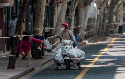 Un livrator aduce o comandă de alimente unei femei din Shanghai, pe 2 mai 2022. | Foto: Profimedia